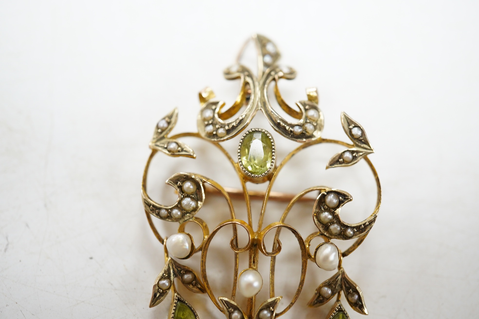 An early 20th century 9ct, peridot and seed pearl cluster set drop pendant brooch, 53mm, gross weight 5 grams. Condition - fair